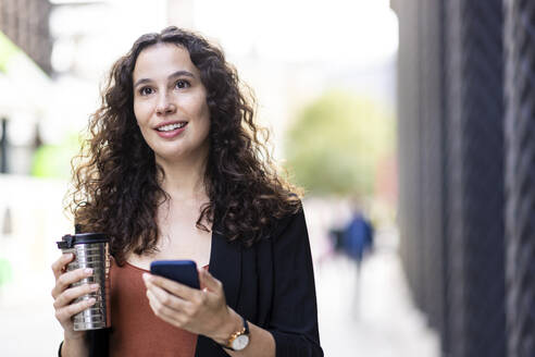 Businesswoman day dreaming with reusable cup - WPEF05762