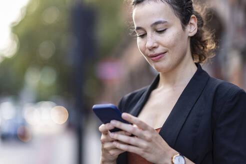 Junge Geschäftsfrau mit Smartphone - WPEF05772