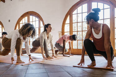 Lehrerin betrachtet Schüler bei ihren Übungen im Yogastudio - JRFF05300