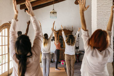 Freunde und Yogalehrer dehnen ihre Hände im Yogastudio - JRFF05301