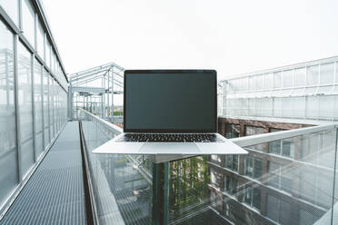 Laptop auf Glasgeländer an Gebäude - JOSEF06604