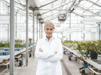 Confident biologist with arms crossed at plant nursery - JOSEF06616