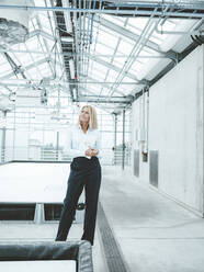 Thoughtful businesswoman standing in industry - JOSEF06645