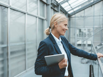 Thoughtful businesswoman with tablet PC in office - JOSEF06673