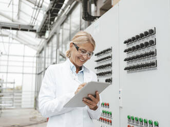 Lächelnder Wissenschaftler mit Tablet-PC in der Industrie - JOSEF06684