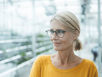 Thoughtful businesswoman with eyeglasses in office - JOSEF06723