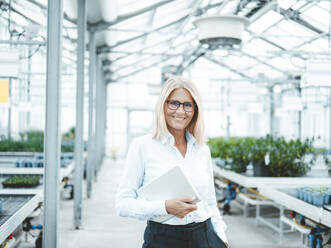 Happy scientist with tablet PC at plant nursery - JOSEF06731