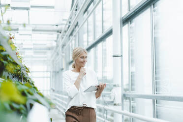 Biologist using tablet PC at plant nursery - JOSEF06746