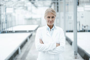 Confident biologist with arms crossed standing in laboratory - JOSEF06802