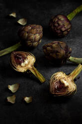 From above ripe green artichokes placed on black table background - ADSF33556