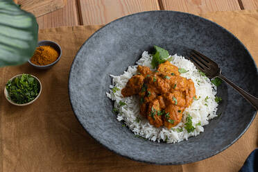 Von oben Huhn garam tikka masala serviert auf Teller auf Holztisch Hintergrund - ADSF33563