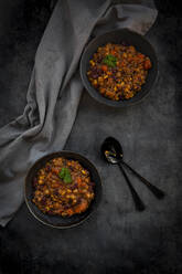 Studioaufnahme von zwei Schüsseln mit veganem Quinoa-Eintopf mit Gemüse und Kichererbsen - LVF09193