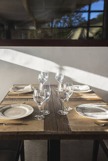 Teller und Weingläser auf dem Tisch im Restaurant - MTBF01139