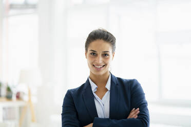 Smiling businesswoman with arms crossed at office - GUSF06727