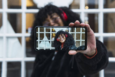 Fröhliche Frau nimmt Selfie durch Smartphone - PNAF02966