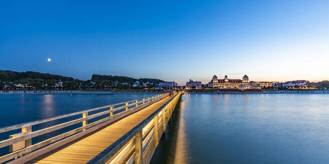 Germany, Mecklenburg-Vorpommern, Binz, Empty pier at dusk with Kurhaus Binz in background - WDF06764