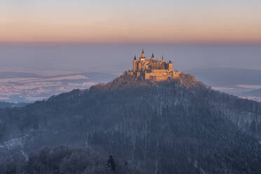 Deutschland, Baden-Württemberg, Blick auf den Hohenzollernberg und die Burg in der Winterdämmerung - RUEF03505