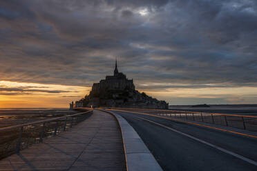 Frankreich, Normandie, Bewölkter Himmel über der Verbindungsbrücke zur Insel Mont-Saint-Michel in der Abenddämmerung - RUEF03507