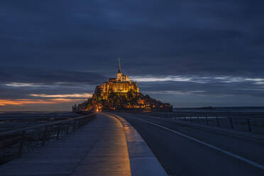 Frankreich, Normandie, Bewölkter Himmel über der Verbindungsbrücke zur Insel Mont-Saint-Michel in der Abenddämmerung - RUEF03510