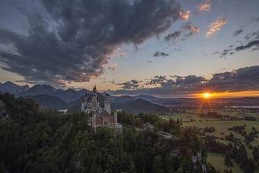 Deutschland, Bayern, Schwangau, Wolken über Schloss Neuschwanstein bei Sonnenuntergang - RUEF03512