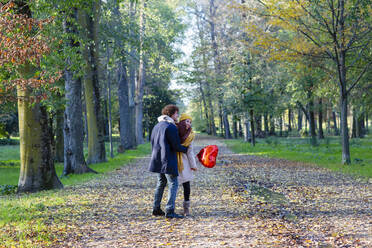 Happy couple with red balloon enjoying at park - EIF03261