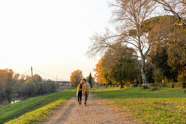 Paar, das gemeinsam auf einem Fußweg im Herbstpark spazieren geht - EIF03301