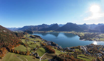 Österreich, Salzburg, Sankt Wolfgang im Salzkammergut, Drohnenansicht des Wolfgangsees und des umliegenden Dorfes an einem sonnigen Herbsttag - WWF06047