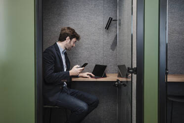 Businessman using tablet PC sitting at desk in cabin - EBBF05370