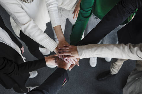 Geschäftsfrauen und Geschäftsmänner, die sich im Büro die Hände reichen - EBBF05423