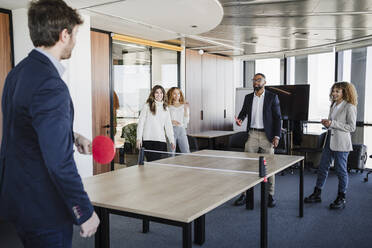 Geschäftskollegen spielen Tischtennis im Coworking-Büro - EBBF05440