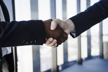 Business colleagues shaking hands in coworking office - EBBF05450