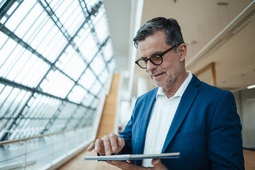 Businessman with eyeglasses using tablet PC at office - JOSEF06939