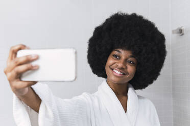 Afro-Frau nimmt Selfie durch Smartphone im Badezimmer - PNAF03003