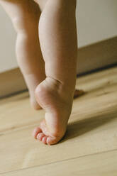 Niedlicher Junge mit nackten Füßen auf dem Boden zu Hause - SEAF00466