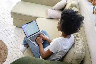 Afro-Geschäftsfrau arbeitet am Laptop im heimischen Wohnzimmer - VPIF05295