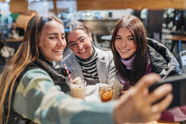 Glückliche junge Freunde nehmen Selfie durch Smartphone im Café - JRVF02712