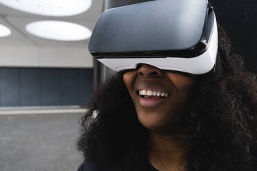 Lächelnde Frau im Virtual-Reality-Simulator - ASGF02100