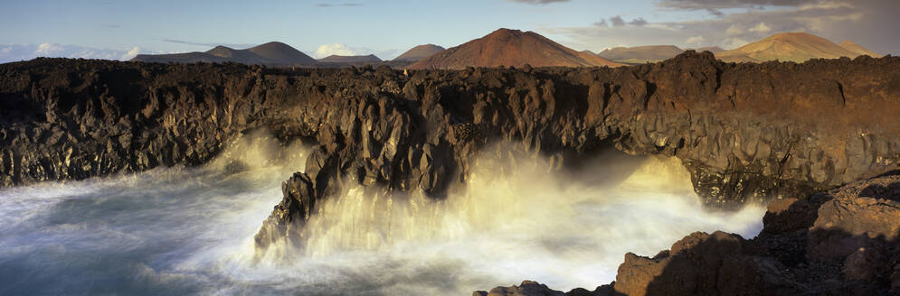 Vulkanische Küste mit Wellen, die in Meereshöhlen krachen, Los Hervideros, Nationalpark Timanfaya, Lanzarote, Kanarische Inseln, Spanien, Atlantik, Europa - RHPLF21180