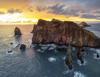 Burning sky at dawn on cliffs washed by ocean, Ponta do Rosto viewpoint, Sao Lourenco Peninsula, Madeira island, Portugal, Atlantic, Europe - RHPLF21252