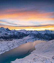 Aerial view of frozen lake Lago Bianco at Bernina mountain pass covered with snow at sunrise, Engadine, Graubunden, Switzerland, Europe - RHPLF21260