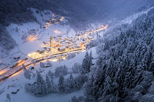Mit Schnee bedeckte Bäume im Winterwald, der das Alpendorf zu Weihnachten umgibt, Valgerola, Valtellina, Lombardei, Italien, Europa - RHPLF21265