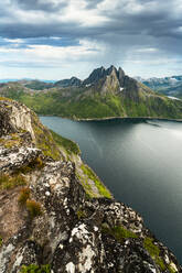 Bewölkter Himmel über dem ruhigen Wasser des Mefjords und dem majestätischen Berg Breidtinden, Insel Senja, Provinz Troms, Norwegen, Skandinavien, Europa - RHPLF21413