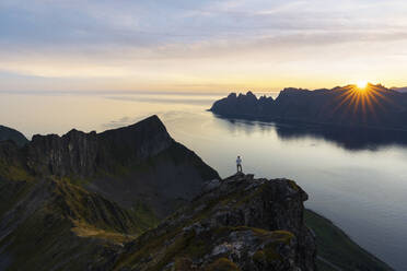 Tourist mit Blick auf den Fjord in der Morgendämmerung auf dem Gipfel des Husfjellet, Insel Senja, Provinz Troms, Norwegen, Skandinavien, Europa - RHPLF21419