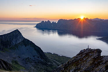 Person admiring the fjord at dawn standing on top of Husfjellet mountain, Senja island, Troms county, Norway, Scandinavia, Europe - RHPLF21422