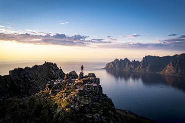 Person contemplating sunset from top of mountains, Senja island, Troms county, Norway, Scandinavia, Europe - RHPLF21423