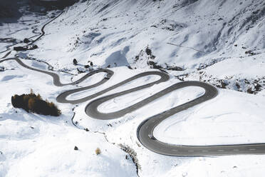 Car traveling on bends of winding road in the snow, Julier Pass, Albula district, Engadine, canton of Graubunden, Switzerland, Europe - RHPLF21429