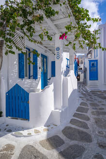 Blick auf ein Mädchen, das durch eine weiß getünchte enge Straße geht, Mykonos-Stadt, Mykonos, Kykladen, Griechische Inseln, Ägäisches Meer, Griechenland, Europa - RHPLF21632