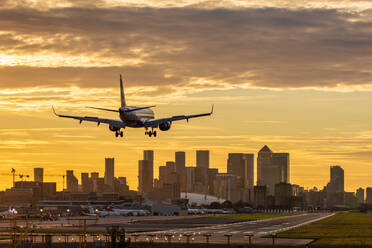 Flugzeuglandung auf dem London City Airport bei Sonnenuntergang, mit Canary Wharf und O2 Arena im Hintergrund, London, England, Vereinigtes Königreich, Europa - RHPLF21676