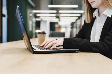 Businesswoman working on laptop in office - EBBF05458