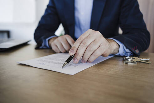 Immobilienmakler erklärt Vertrag auf dem Tisch im Büro - EBBF05511